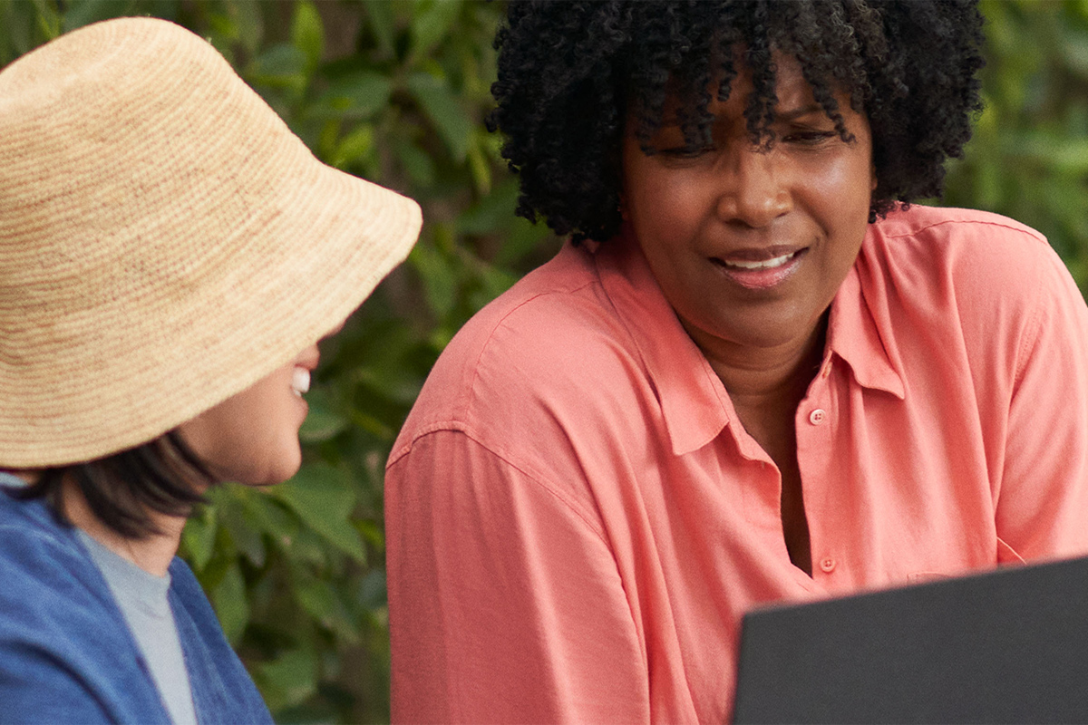 Twee vrouwen aan het praten terwijl ze een PCSpecialist met Windows 11 gebruiken
