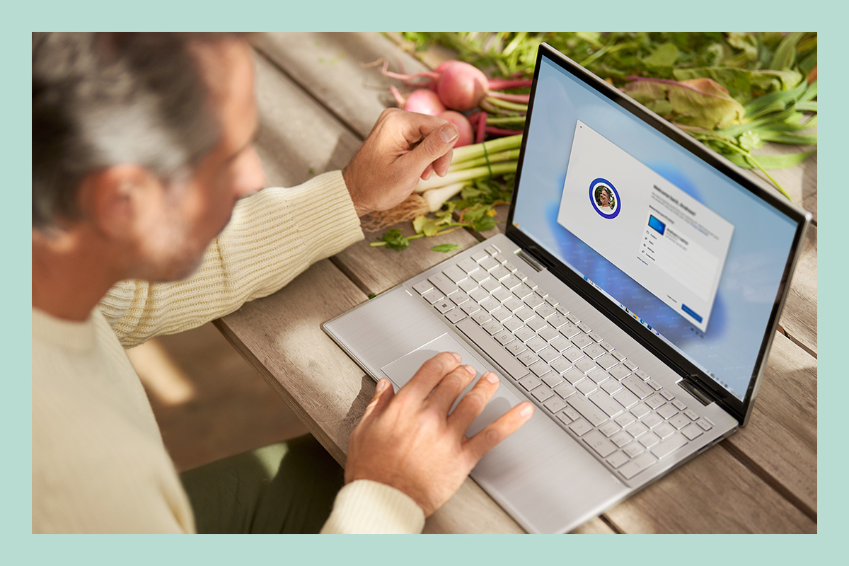 Een man op een laptop die bestaande bestanden, apps en standaard configuraties via Windows 11 instelt.