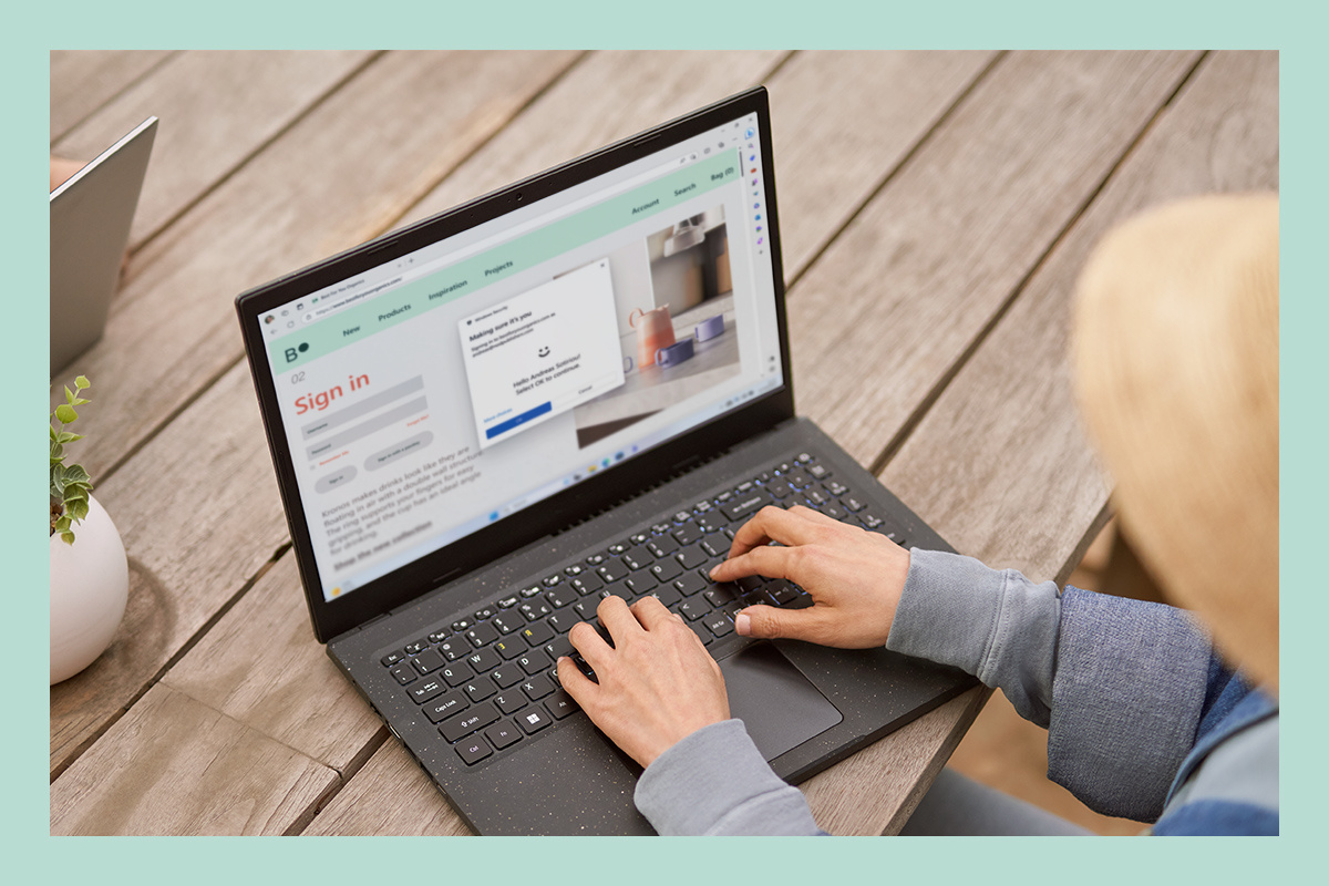 Een vrouw op een laptop die van de ingebouwde beveiliging van  Windows 11 gebruik maakt.