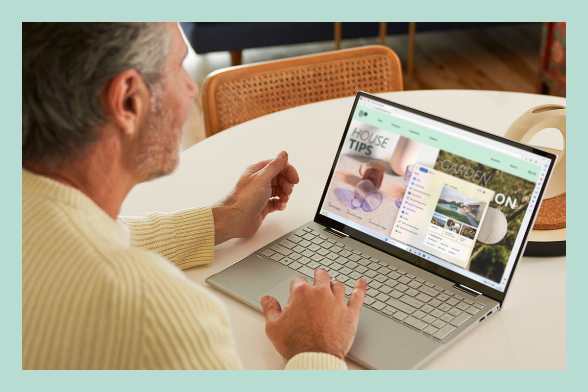 Een man aan het werk op een laptop met Windows 11.
